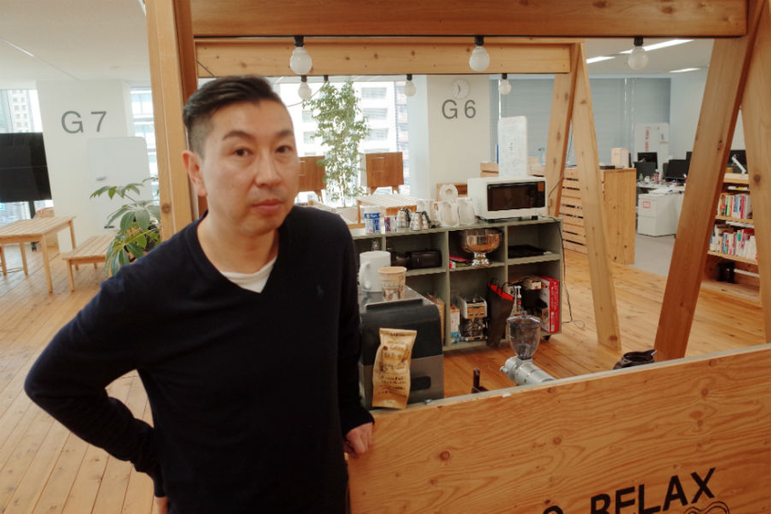 Akio Iida surrounded by products made from Ishinomaki rubber tree wood