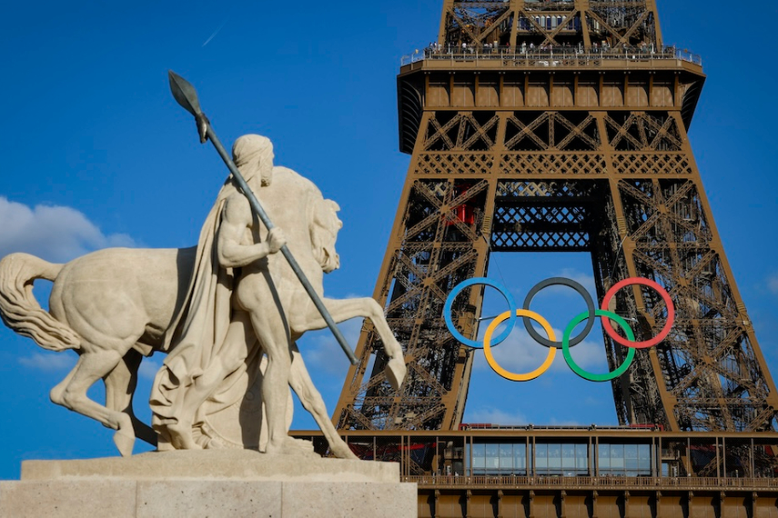 The Olympic rings on the Eiffel Tower near the restored statue of Cavalier Arabe in Paris. (Photo credit: Geoffroy Van Der Hasselt / Getty Images)